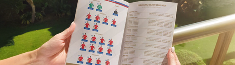 Osoba przegląda broszurę sportową.